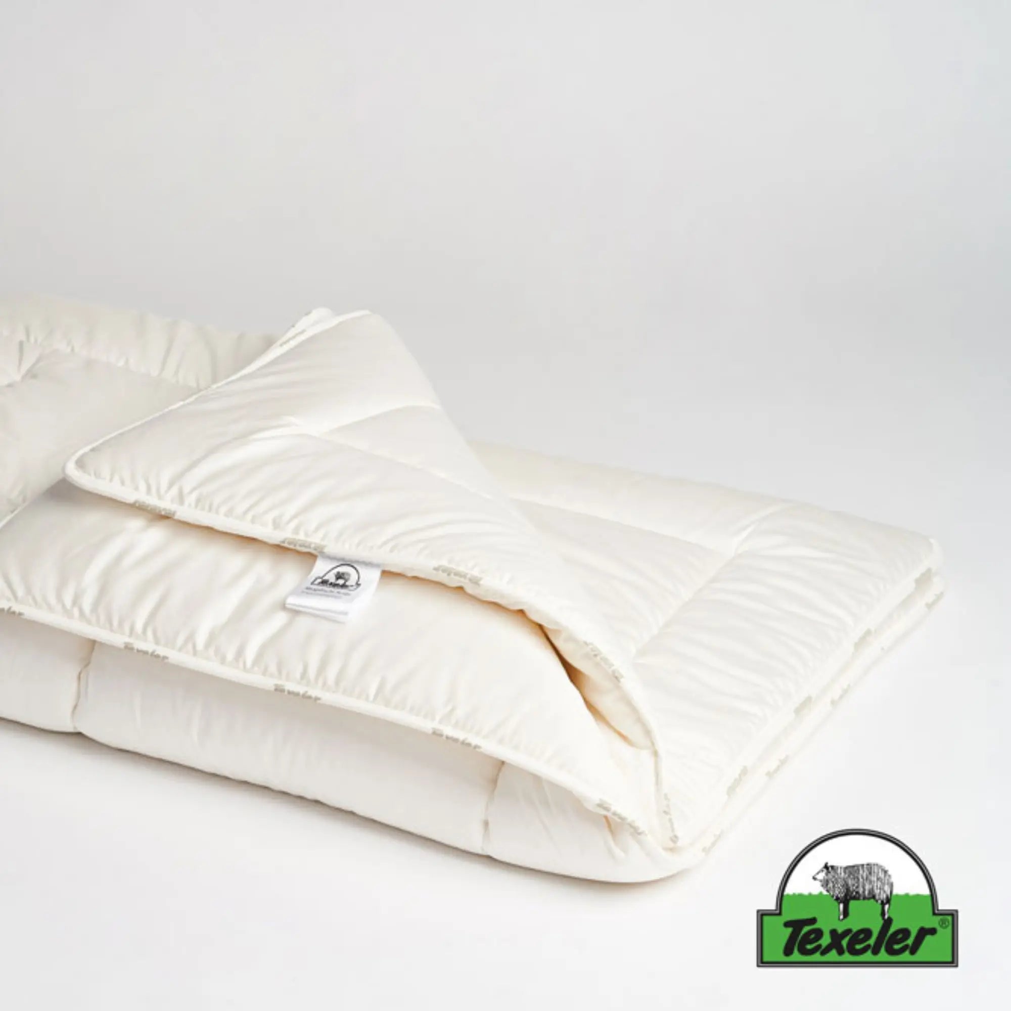 texeler sleep well satin wool comforter laying flat on a white background with the corners folded over. 