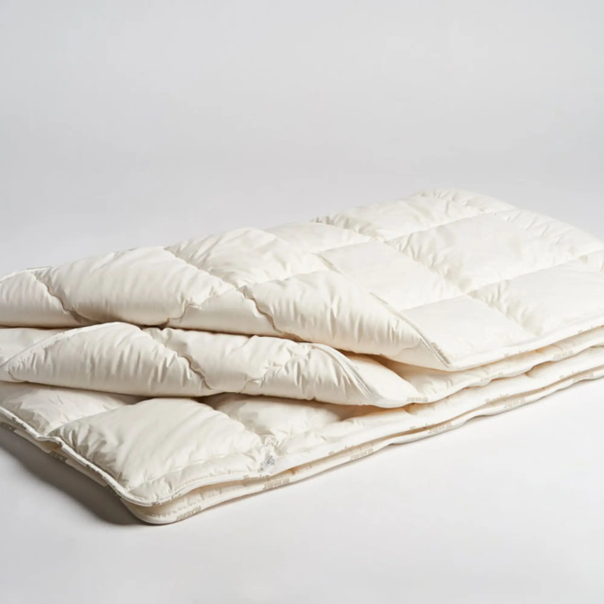 Texeler pure nature perkal wool comforter laid flat on a white background with two folds to see the multiple layers. 