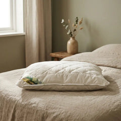 Pillow lying flat on the linen bed in the warm bedroom backdrop